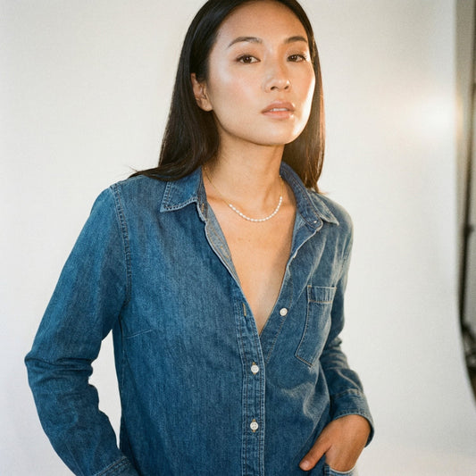 Woman wearing a blue denim shirt against a plain background