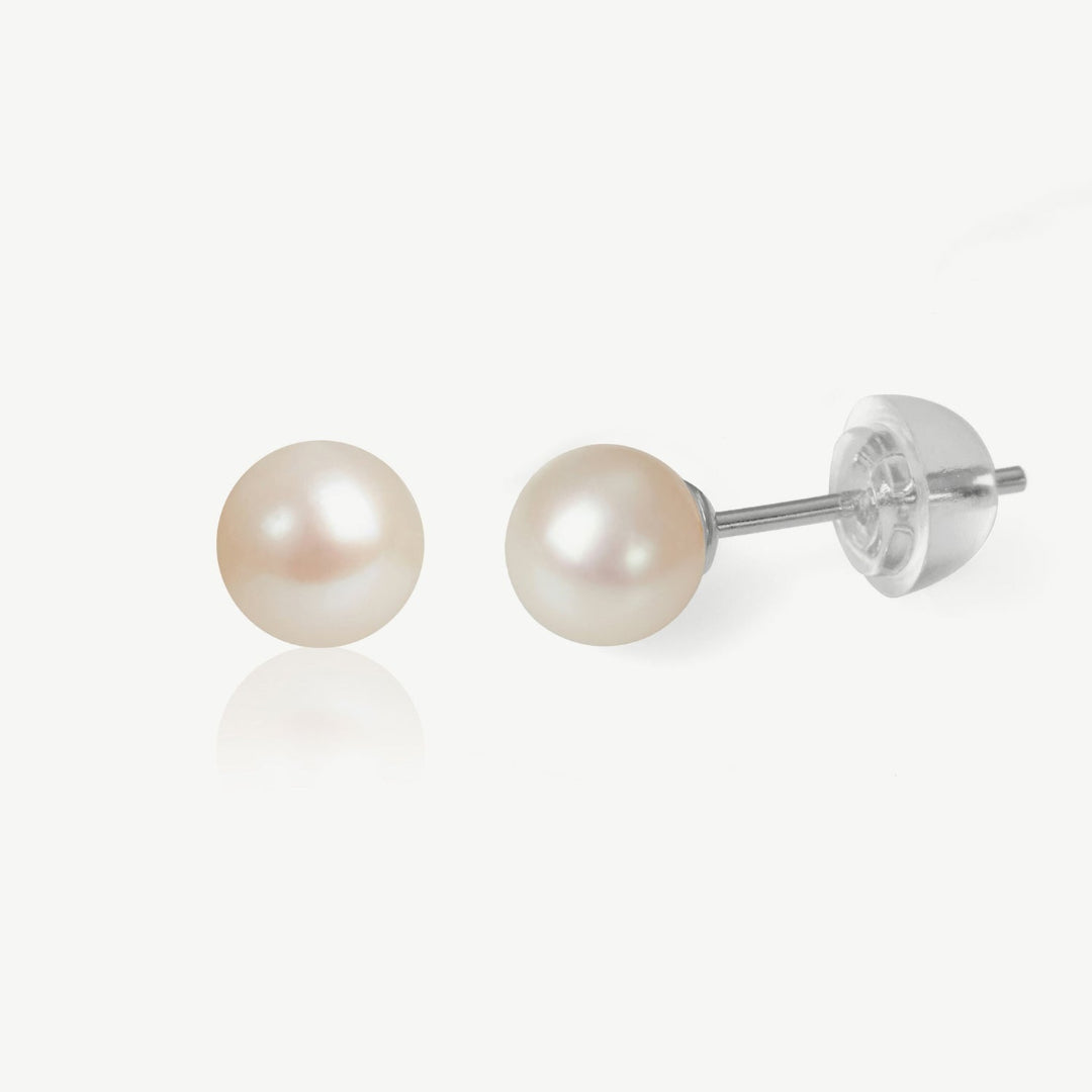 Pair of pearl stud earrings on a white background
