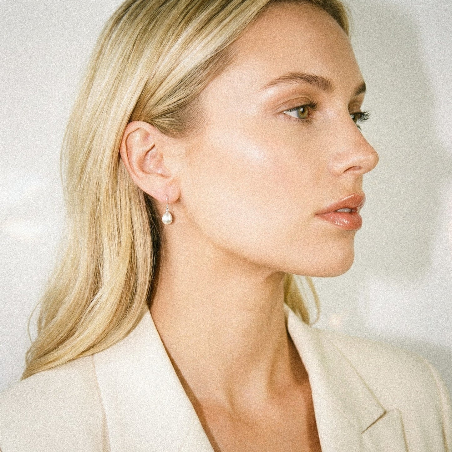 Woman wearing a white blazer with a blurred background
