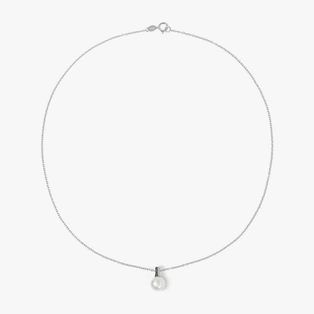 Silver necklace with a small pendant on a light gray background