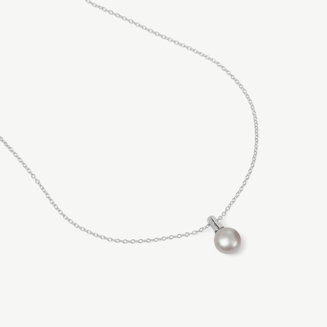 Pearl necklace on a light gray background