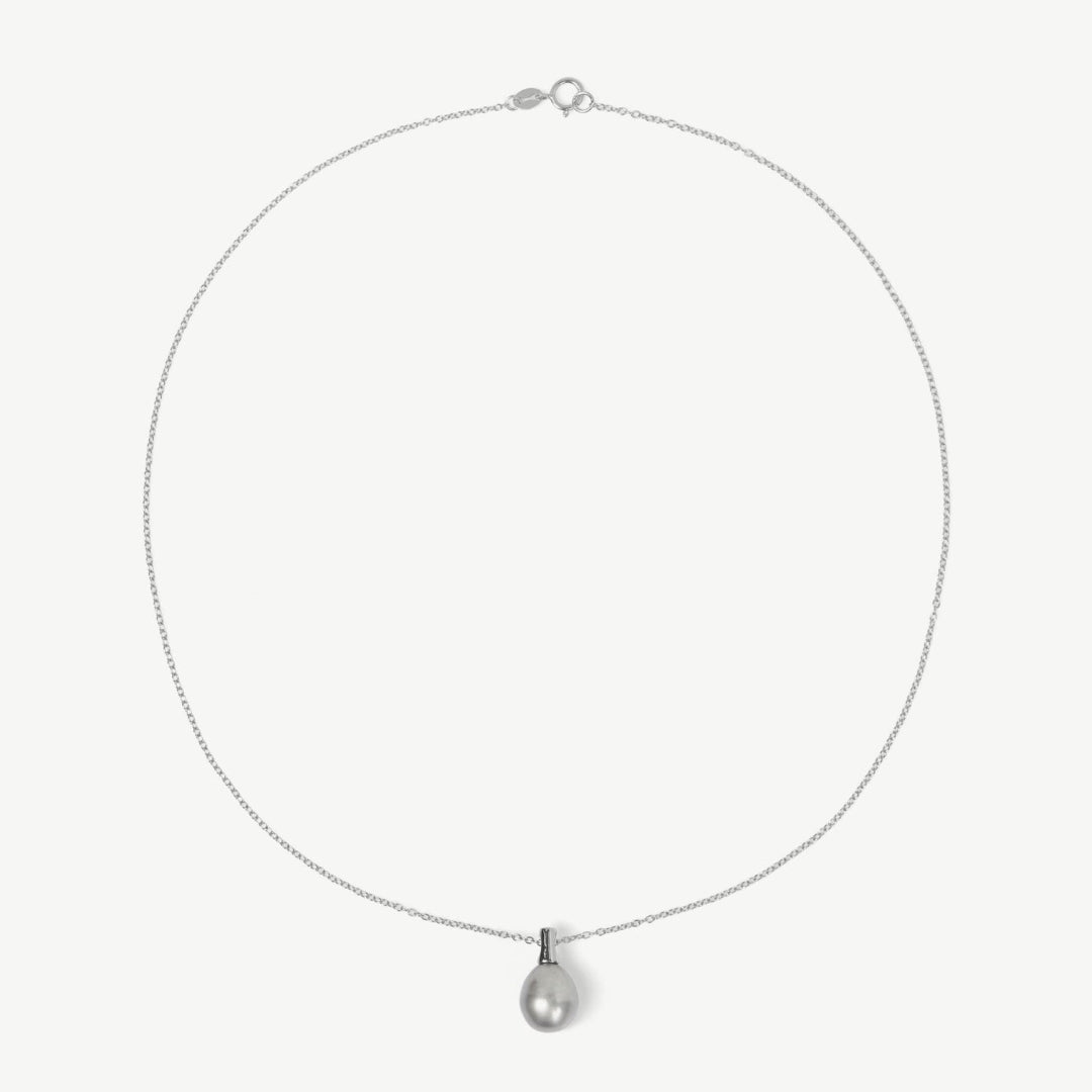 Silver necklace with a teardrop-shaped pendant on a light gray background
