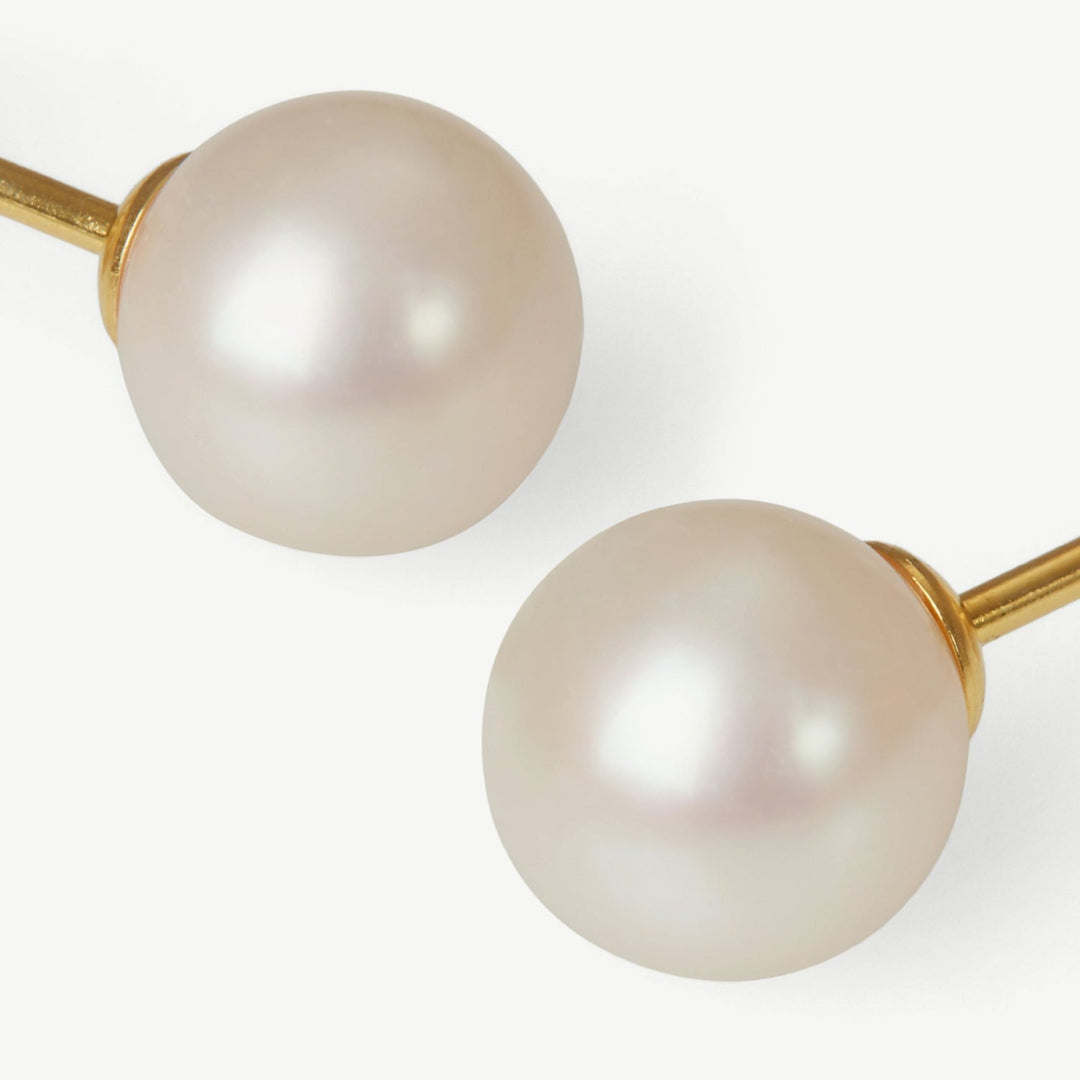 Pearl earrings with gold clasps on a white background