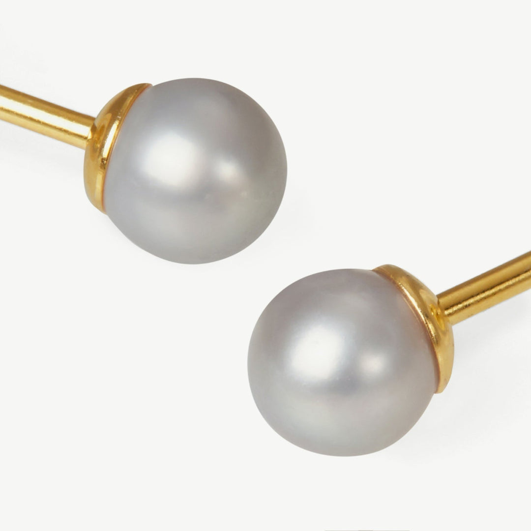 Pearl earrings with gold posts on a white background