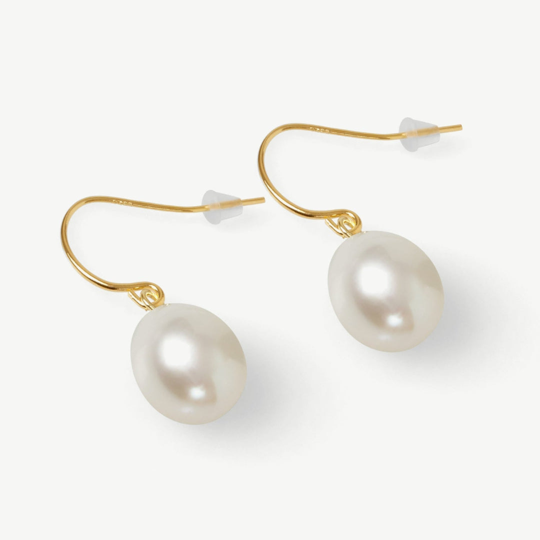 Pearl earrings with gold hooks on a white background