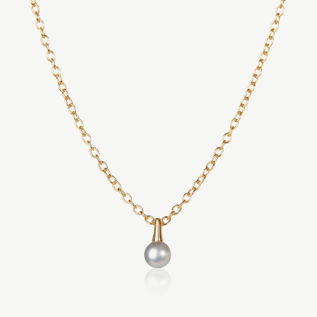 Gold necklace with a single pearl pendant on a white background