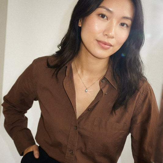 Woman wearing a brown shirt against a plain background