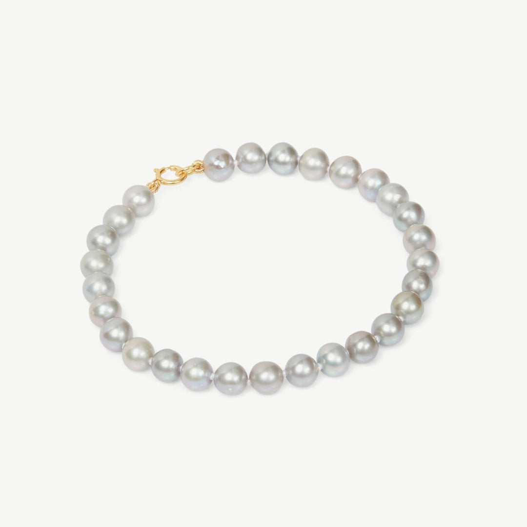 Pearl bracelet with a gold clasp on a white background