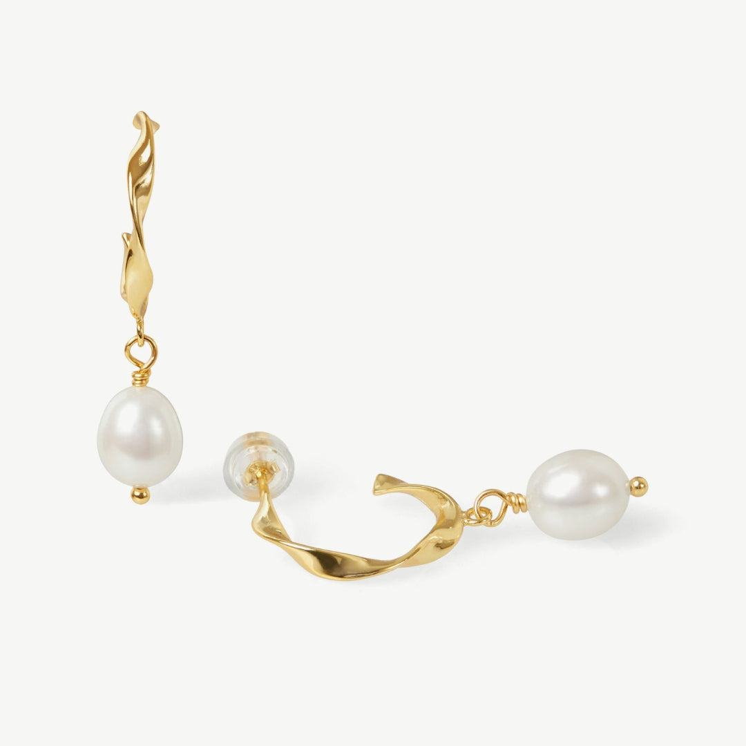 Gold earrings with pearls on a white background
