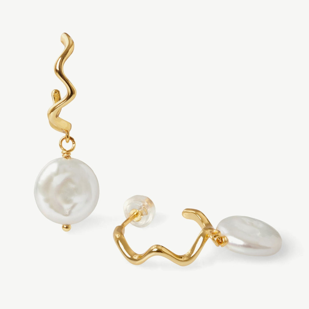 Gold and pearl earrings on a white background