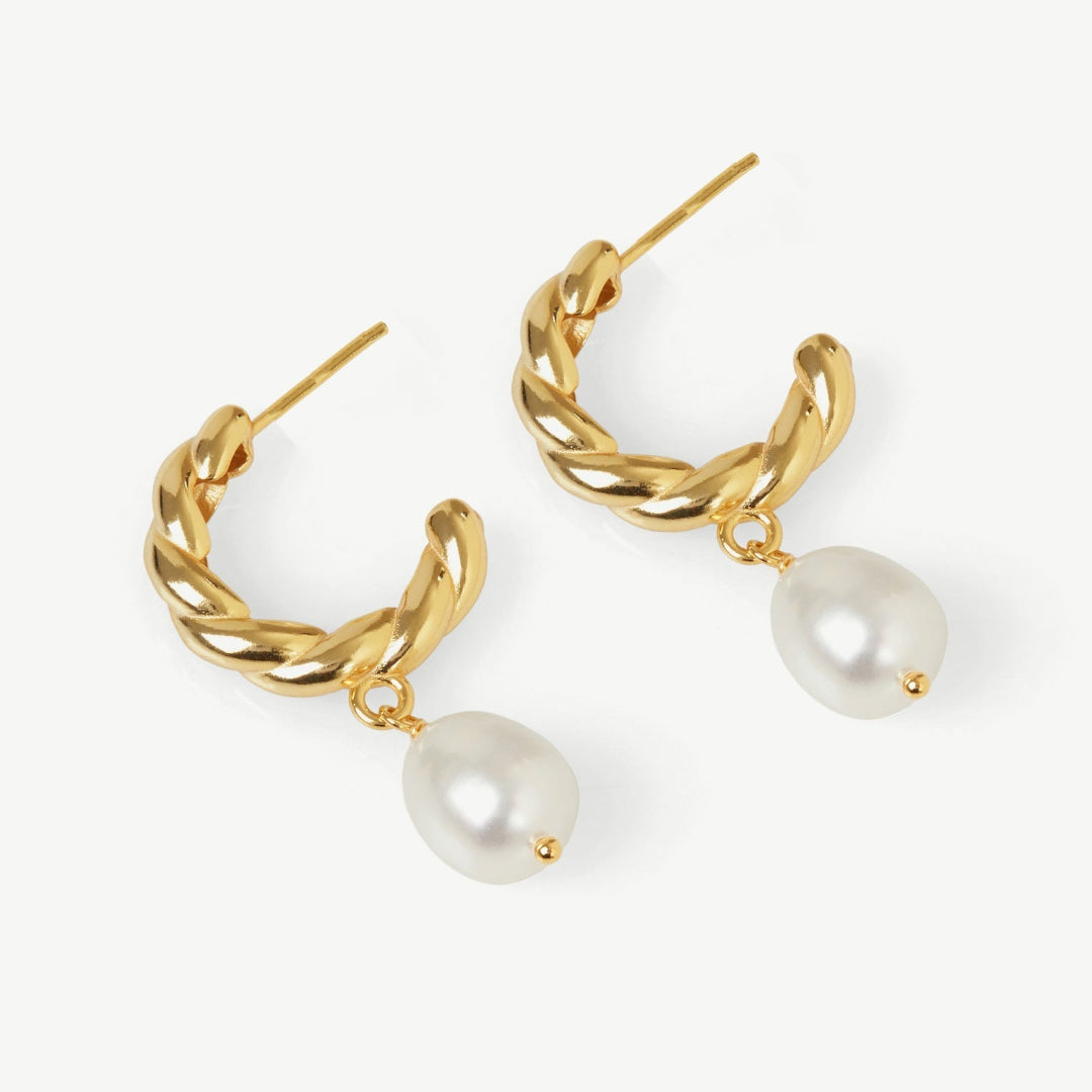 Gold hoop earrings with pearl drops on a white background