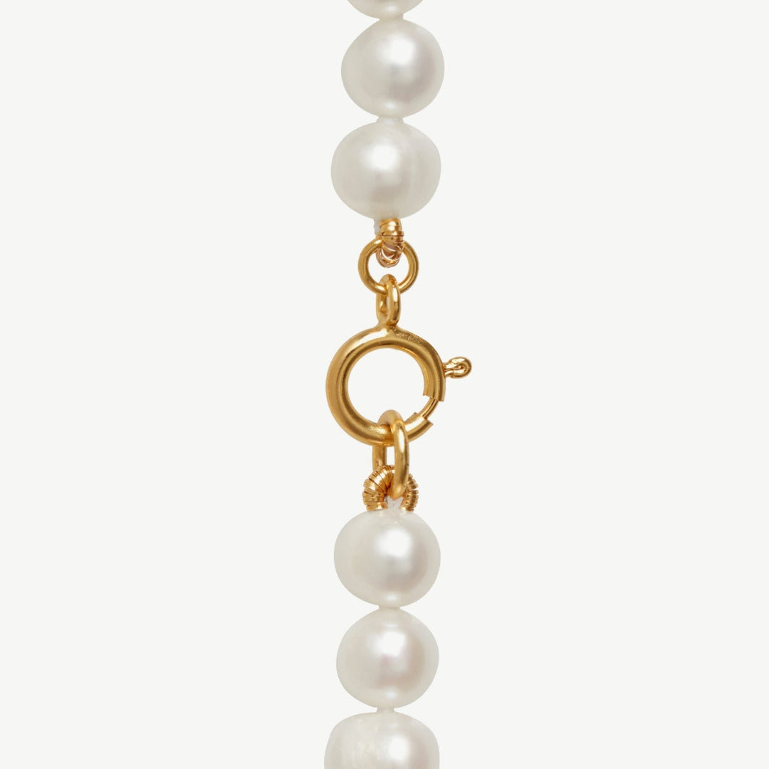 Pearl necklace with a gold clasp on a white background