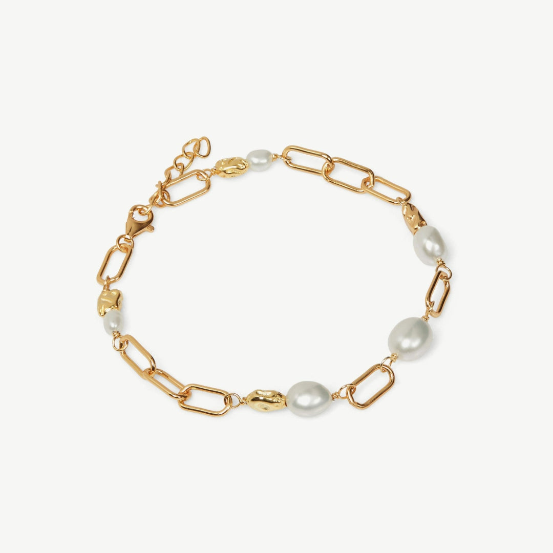Gold chain bracelet with pearls on a white background