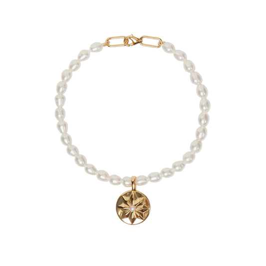 Pearl bracelet with a gold clasp and pendant on a white background