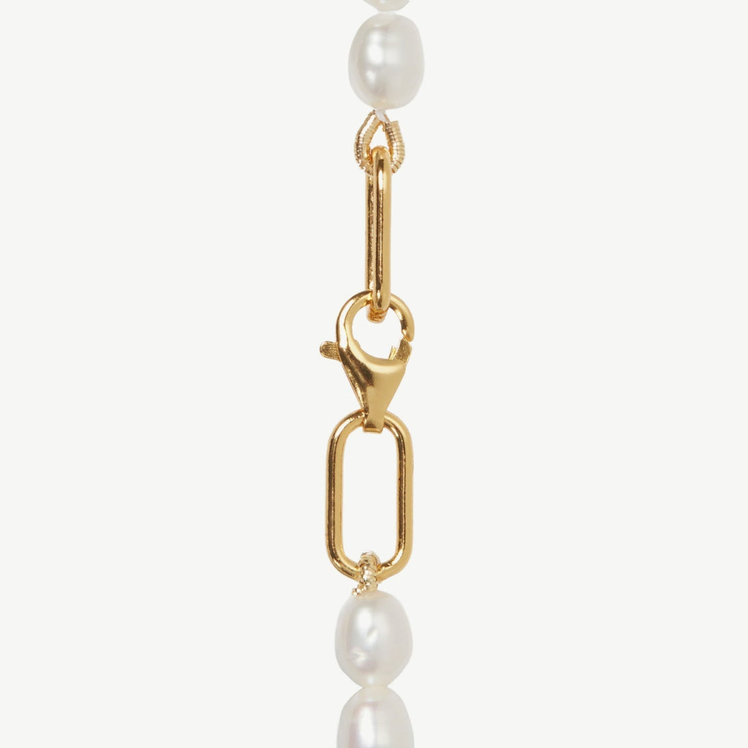 Gold chain with pearl beads on a white background