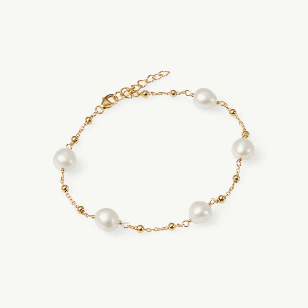 Gold bracelet with pearls on a white background