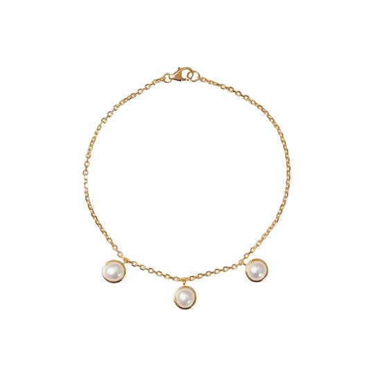 Gold bracelet with three pearl charms on a white background