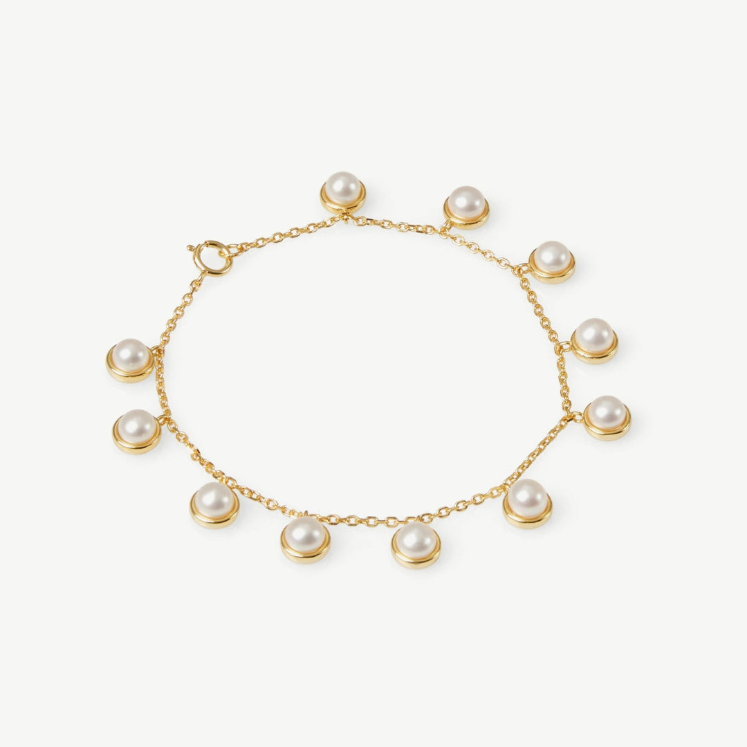 Gold bracelet with pearls on a white background