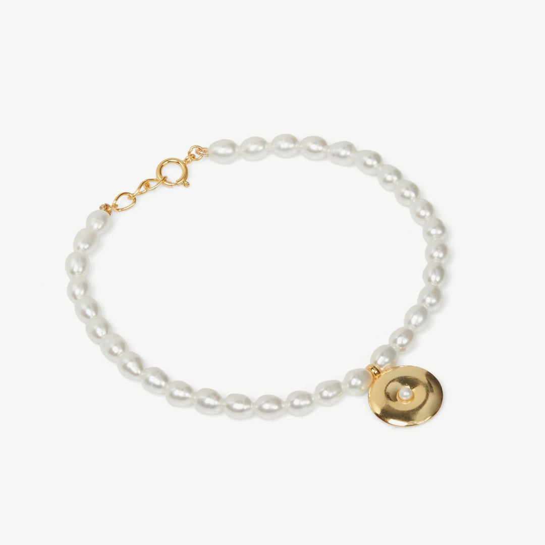 Pearl bracelet with gold clasp on a white background