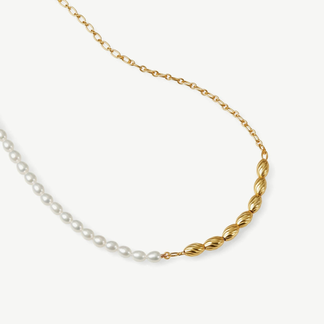Gold and pearl necklace on a white background