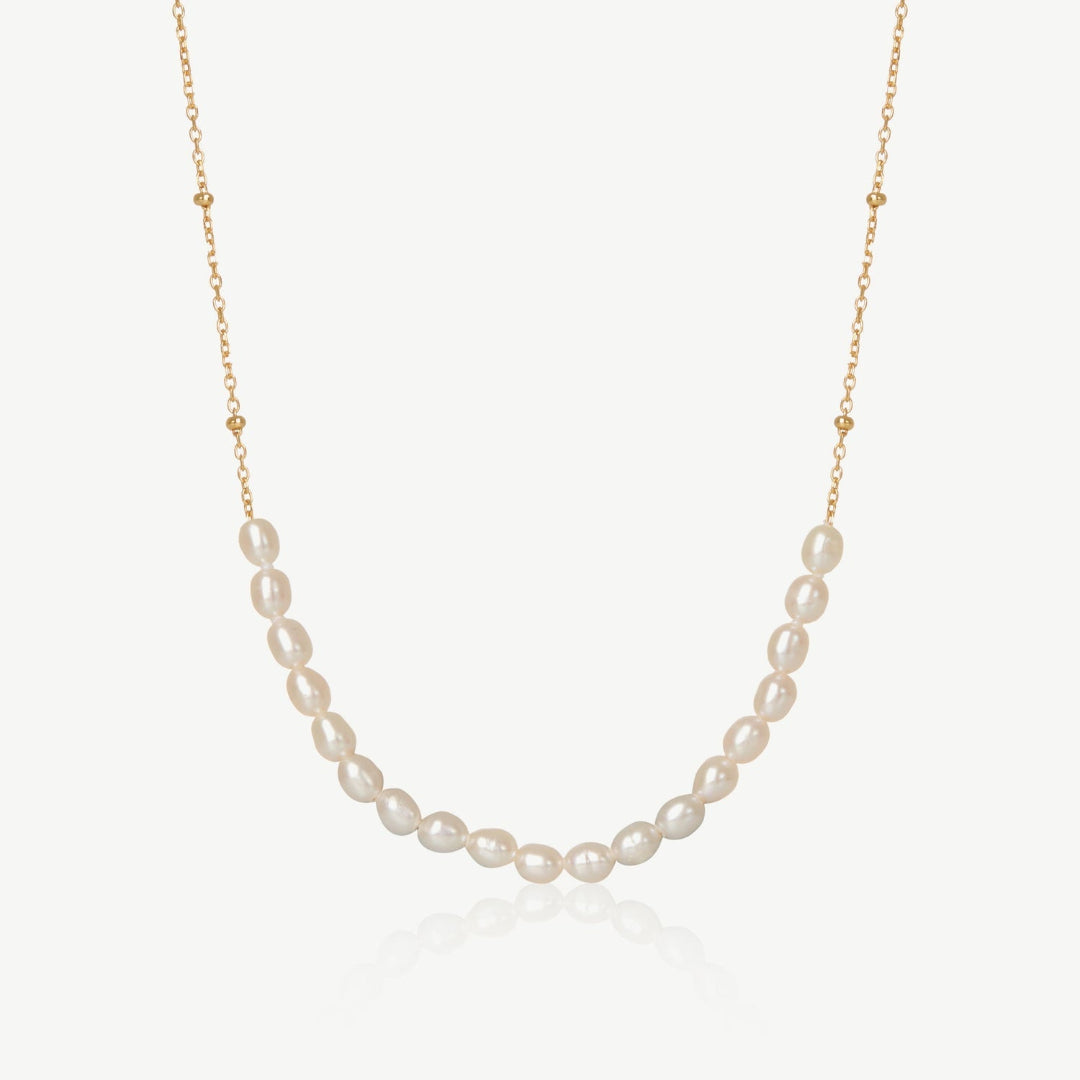 Pearl necklace on a gold chain against a white background