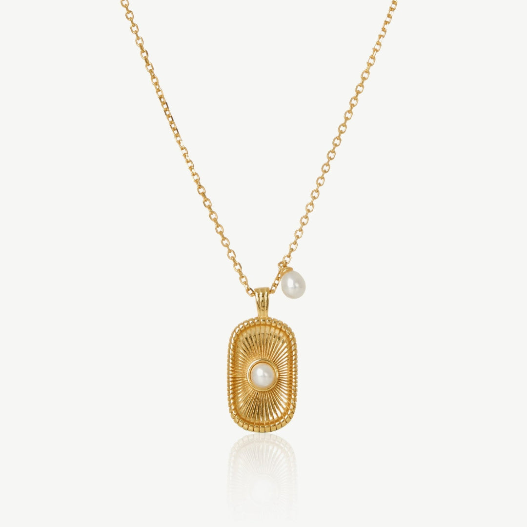 Gold necklace with a rectangular pendant and pearl on a white background