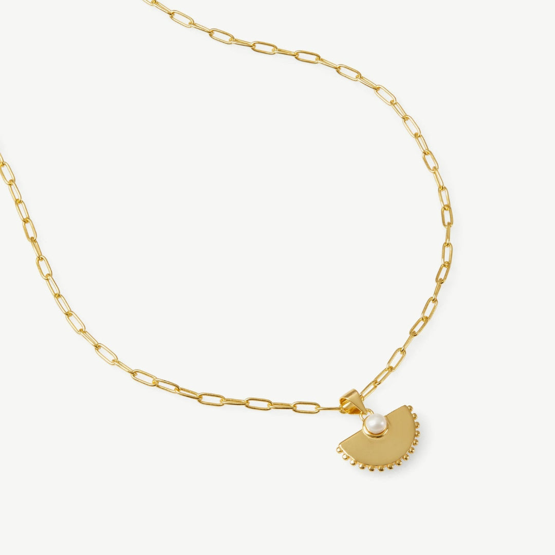 Gold necklace with a unique pendant on a white background