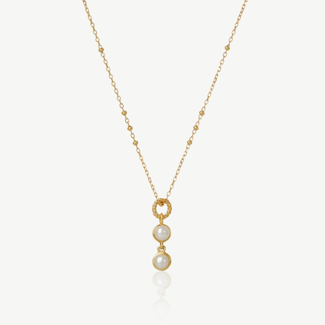 Gold necklace with pearl pendant on a white background