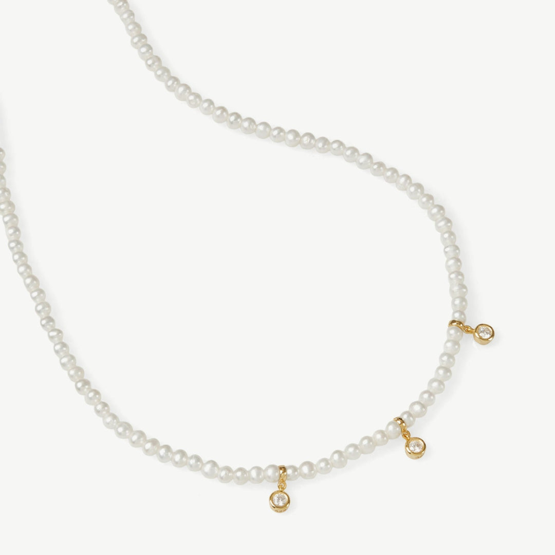 Pearl necklace with gold clasp on a white background