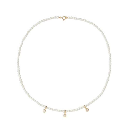 Pearl necklace with gold accents on a light gray background