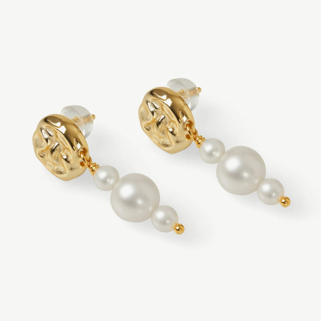 Pearl and gold earrings on a white background