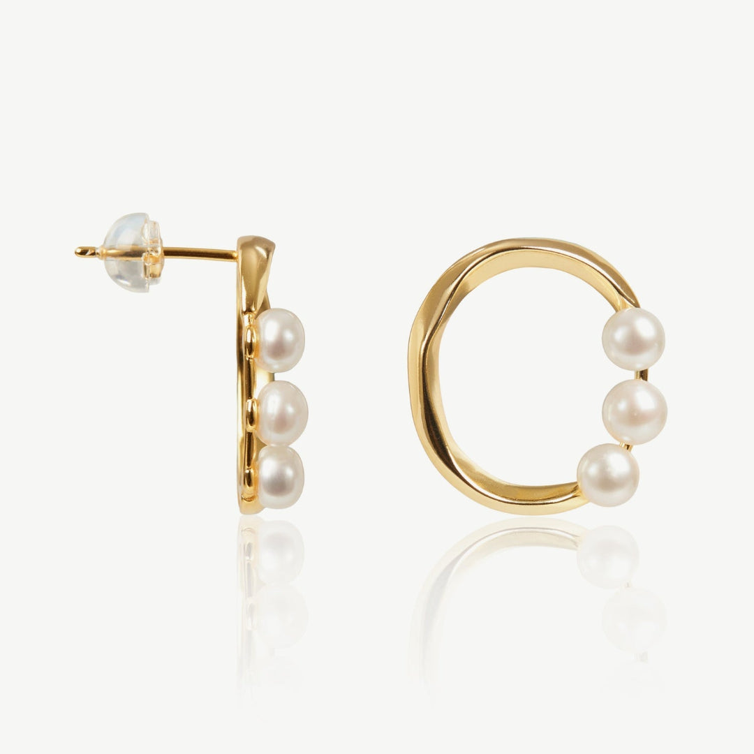 Gold hoop earrings with pearls on a white background