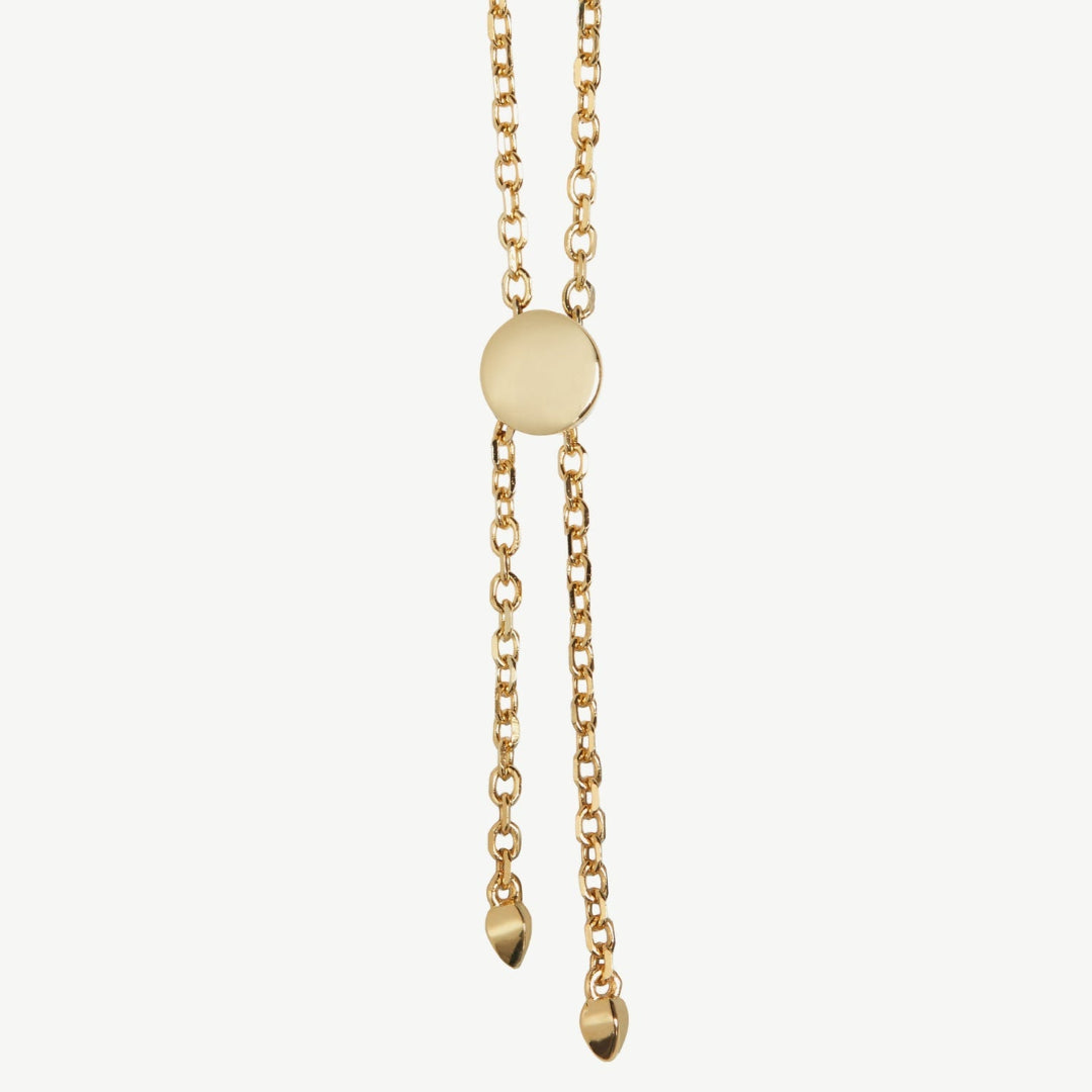 Gold necklace with a round pendant and hanging droplet on a white background