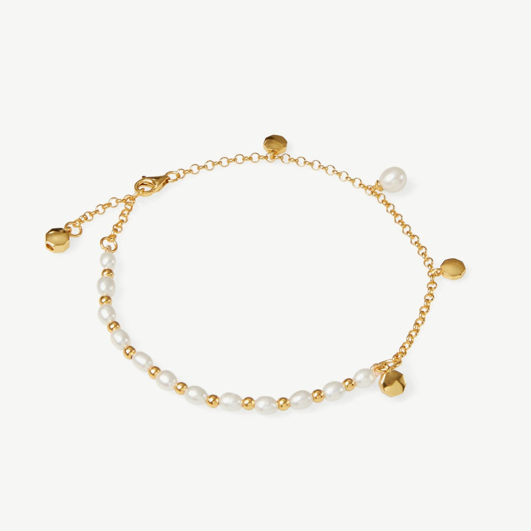Gold bracelet with pearls on a white background