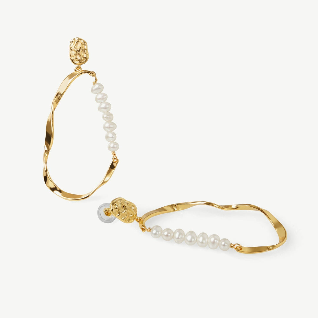 Gold hoop earrings with pearl beads on a white background