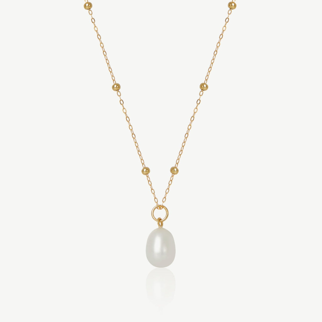 Gold necklace with a pearl pendant on a white background