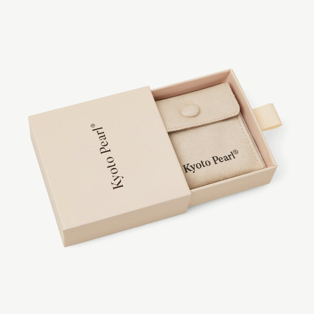 Beige jewelry pouch in a 'Kyoto Pearl' branded box on a white background