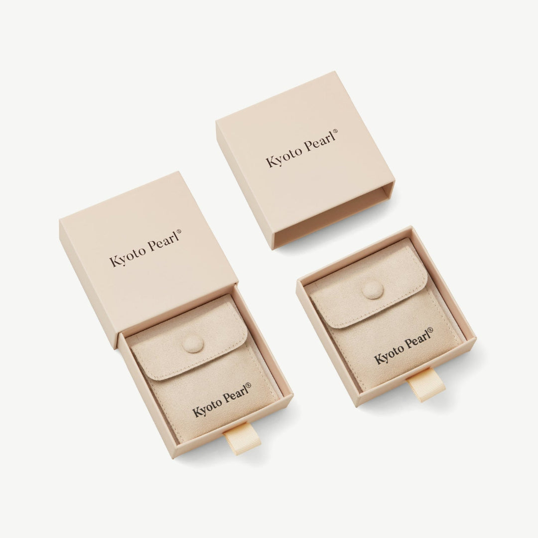 Beige jewelry boxes with Kyoto Pearl branding on a white background