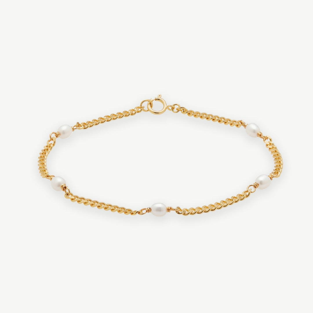Gold chain bracelet with pearls on a white background