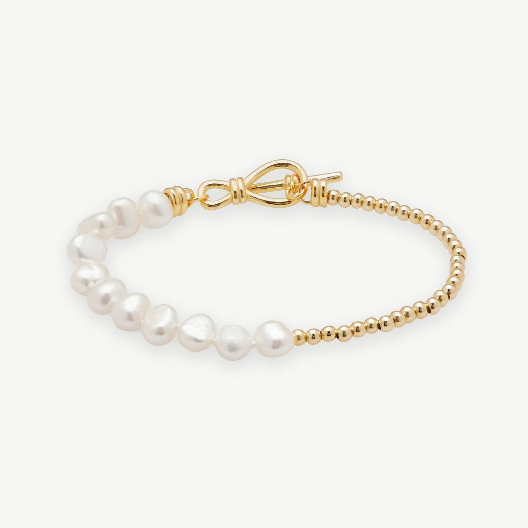 Pearl bracelet with gold clasp on a white background