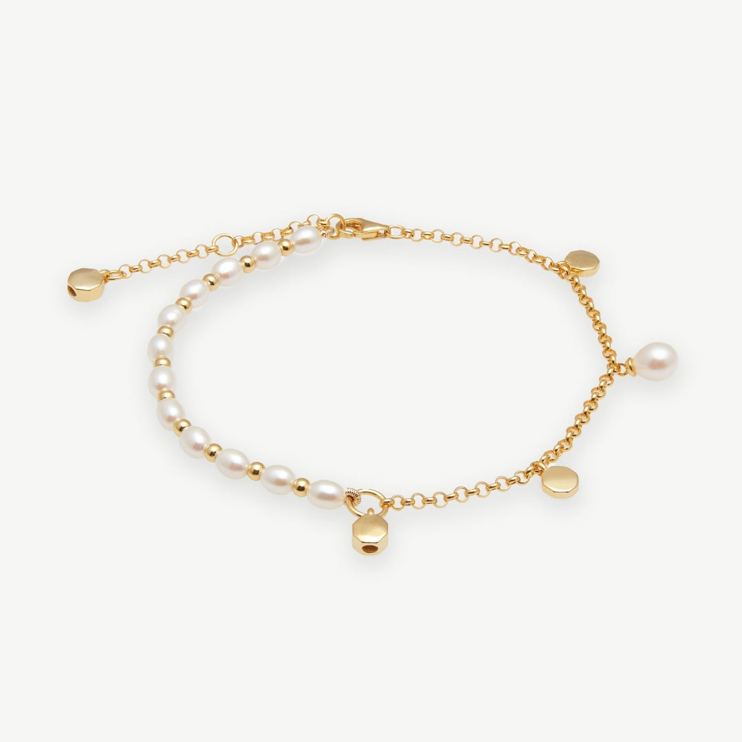 Gold bracelet with pearls on a white background