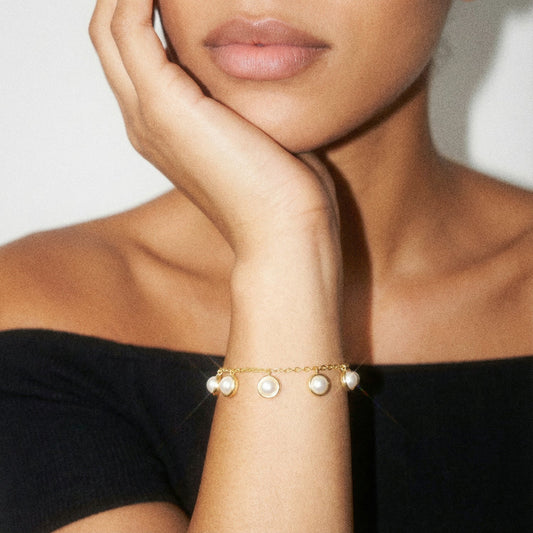 Woman wearing a pearl bracelet on a neutral background