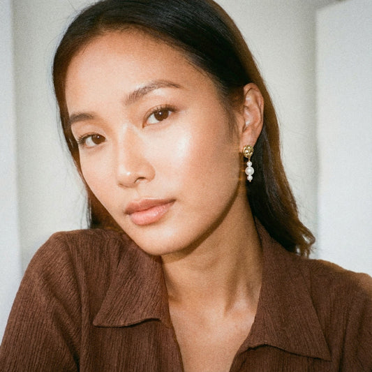 Woman wearing a brown shirt with a neutral background